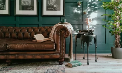 Brown leather Chesterfield sofa in a dark green contemporary interior