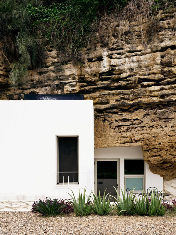 Modern white boxes combine with ancient cave to create an artists home