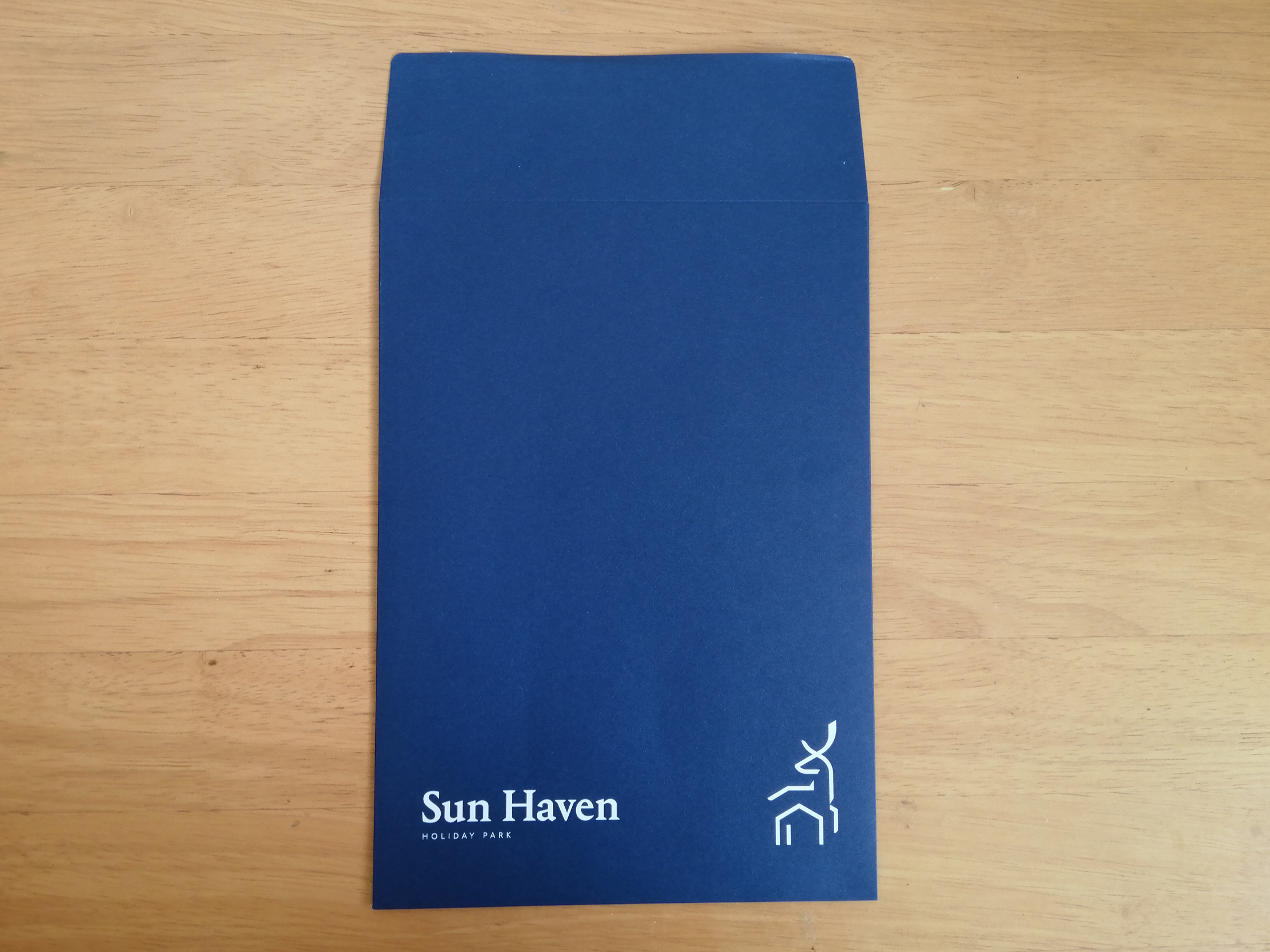 Deep blue C5 envelope designed for Lovat Holiday Parks welcome packs