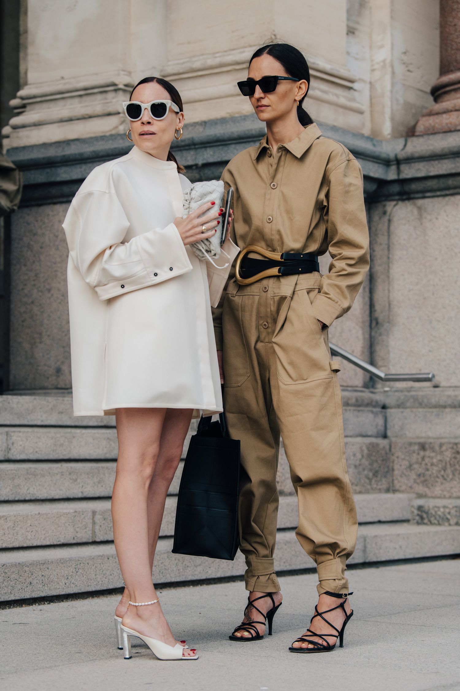 Two women snapped in stylish goats and overalls