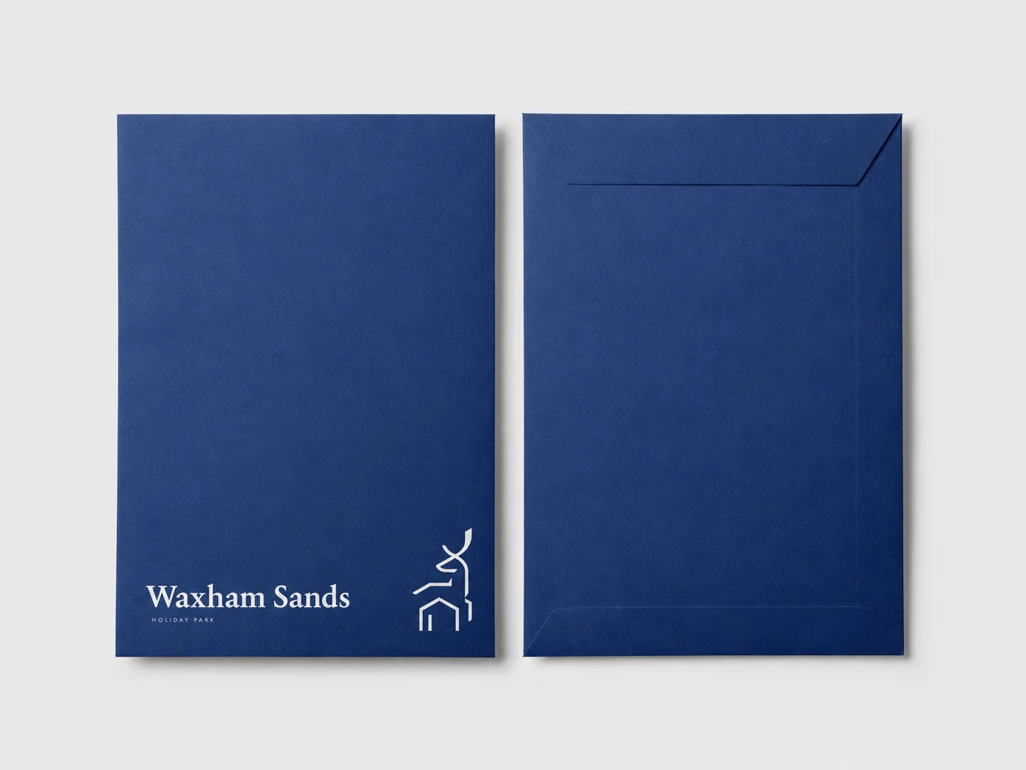 Deep blue Waxham Sands welcome pack envelope shown front and back