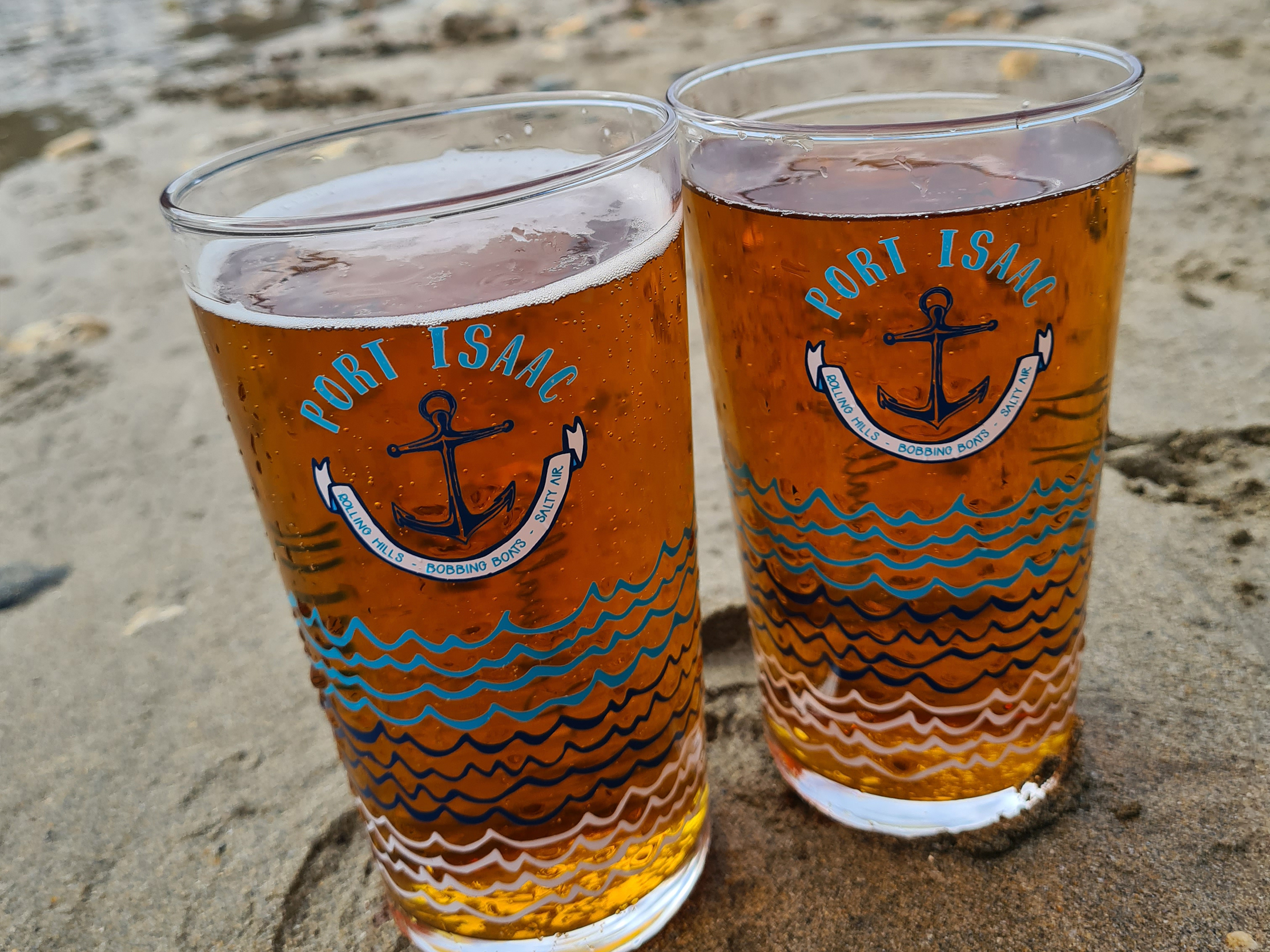 Detail of the Harbour Treats pint glass with anchor, waves and Port Isaac lettering